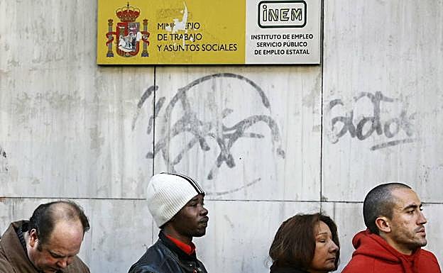 Varias personas hacen cola ante la oficina del INEM en Madrid. 