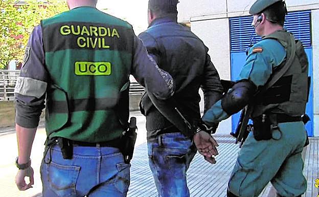Uno de los detenidos es trasladado por agentes de la UCO.
