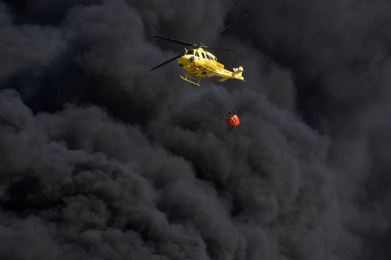 Los bomberos trabajan en la extinción de un incendio en una empresa de reciclaje de residuos en Santomera que ha originado una gran columna de humo a primera hora de la tarde, alrededor de las 16.30 horas de este miércoles.