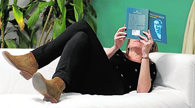 Una lectora disfruta con los versos de María Cegarra. A la izquierda, un retrato de la poetisa. 