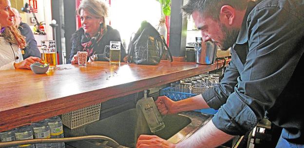 Un camarero aclara una jarra de cerveza con agua del grifo, ayer, en un bar del casco antiguo.