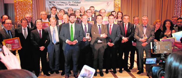Posado de los premiados con el presidente del Ejecutivo autonómico, Fernando López Miras, y otras autoridades y miembros de la DOP.