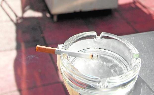 Un cigarro en un cenicero, en la terraza de un bar.