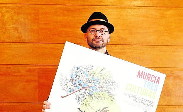 El autor del cartel, Manuel Pérez, junto a su obra.