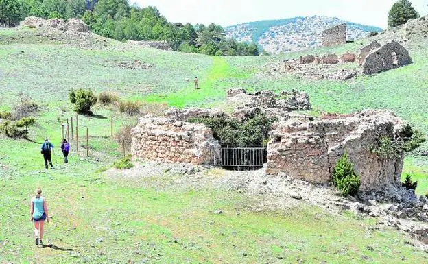 Unos excursionistas atraviesan el prado de los pozos de la nieve de Murcia, que se desmoronan a pasos agigantados.