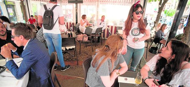 Colaboradores de Hostemur entregan las pegatinas en la plaza de Santa Catalina.