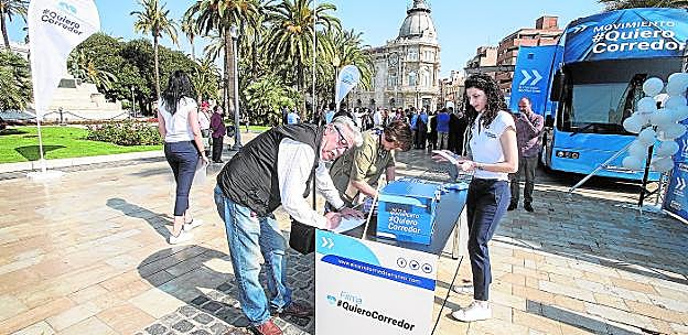 Dos vecinos firman en favor de la llegada del Corredor Mediterráneo a Cartagena, en una mesa instalada ayer en la Plaza Héroes de Cavite.