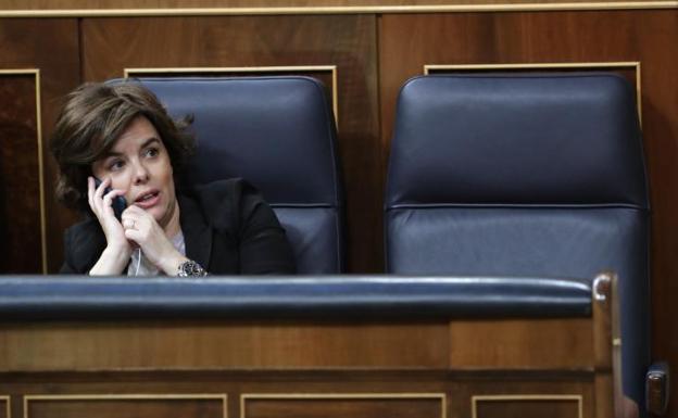 La vicepresidenta del Gobierno habla por teléfono junto al escaño vacío de Rajoy durante el debate de la moción de censura en su contra.
