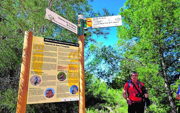 Manuel Águila, técnico de Medio Ambiente, junto a los carteles de señalización de la red de senderos e información ambiental de la sierra de la Muela.