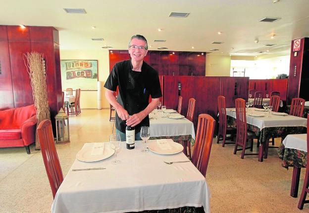 Cristóbal, propietario de La Chara, preparando el comedor de su restaurante.
