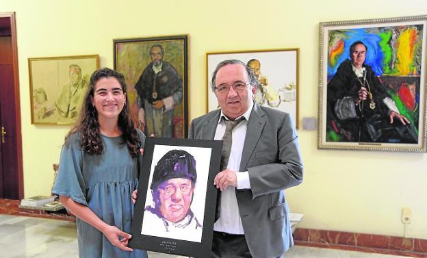 José Orihuela recibe de manos de María Garres la obra vencedora del concurso 'Retrata a tu Rector'.