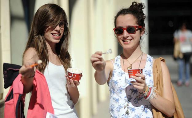 Dos jóvenes alivian las altas temperaturas de la capital murciana con un helado.