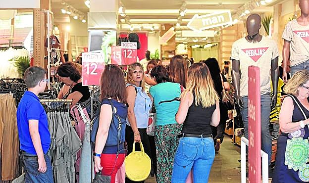 Varios clientes realizan sus compras en una tienda del centro de la ciudad en el primer día de rebajas. 