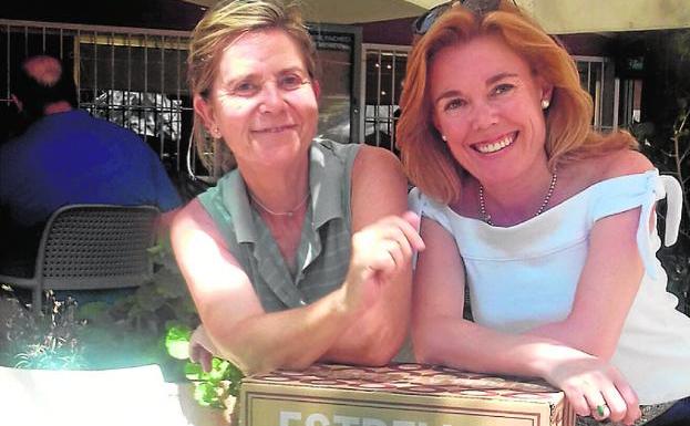 A la sombra de una Estrella. Sombrillas, mesas y sillas visten la terraza del club donde las ganadoras Maloles Durán y Encarna Martínez posan con parte de su premio. 
