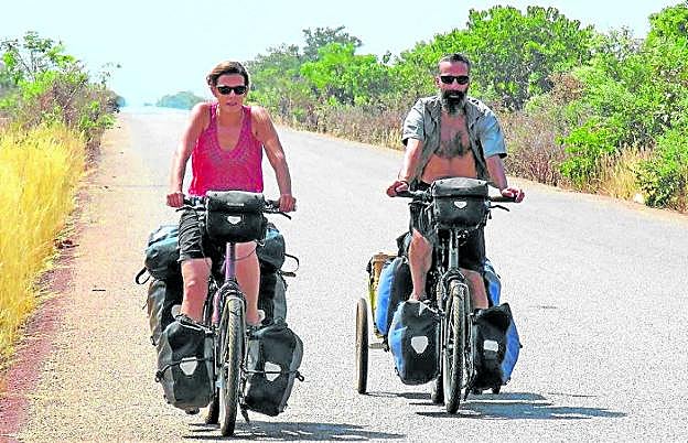 'Cinecicleta'. Isabel y Carmelo pedalean por una carretera de Burkina Faso con el cine a cuestas durante su aventura africana. 