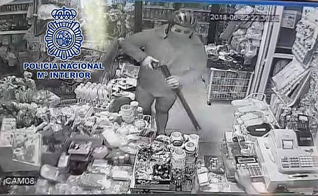El atracador encañona a un empleado.