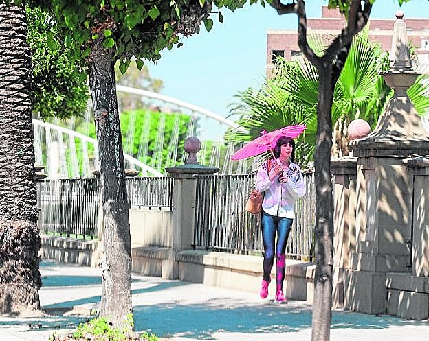 Una mujer se protege del intenso calor con un parasol, ayer en el centro de Murcia. 