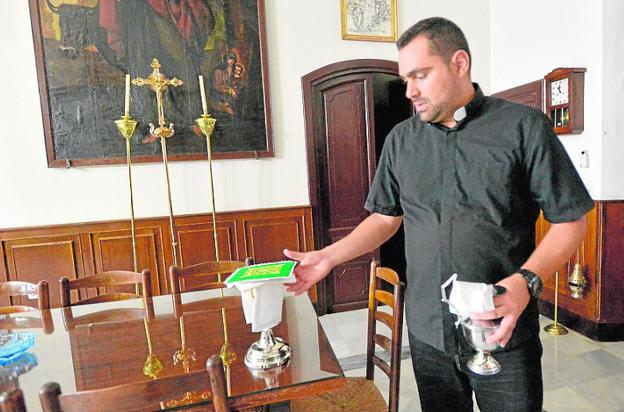 Un sacerdote muestra los objetos que fueron sustraídos. 