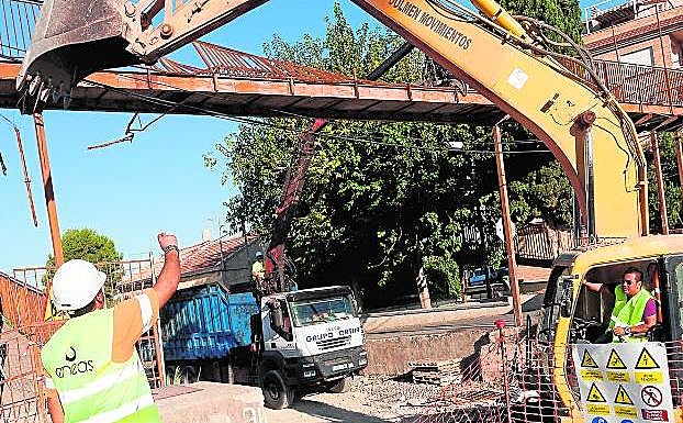 Un operario dirige los trabajos de la grúa que derribó la pasarela de San José de la Vega. caval/agm
