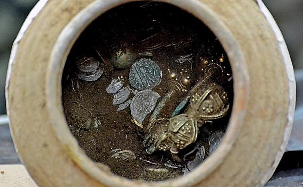 Imagen de una vasija de cerámica con objetos dorados en su interior que forman parte del tesoro descubierto recientemente en la fortaleza de Kaliakra. 