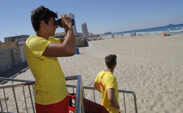 Un socorrista mira a través de unos prismáticos en una playa de La Manga.