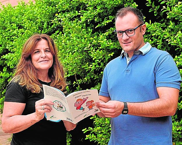 La sargento Emilia y el agente Celdrán, ayer, con el libro en el Archivo Regional. 