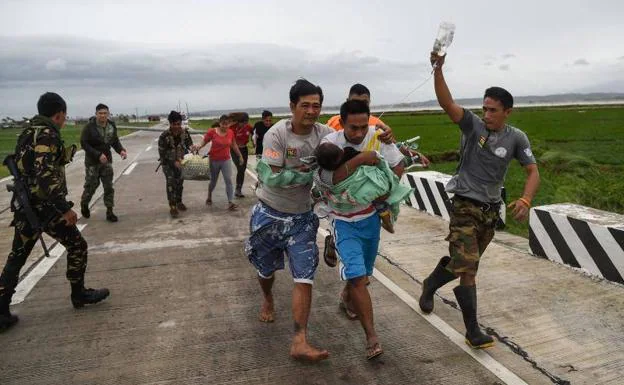 Soldados filipinos asisten a una familia durante las labores de rescate.