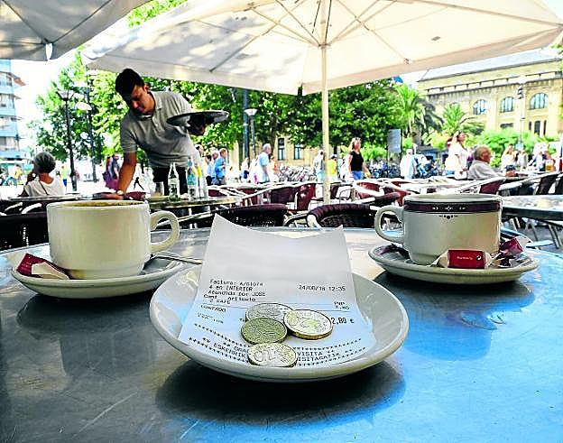 La cuenta por dos cafés, junto a la propina en la terraza de un bar. 