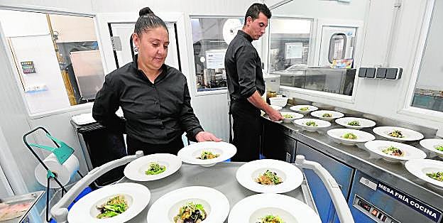 Susana Atienza, junto a un compañero, dando un último repaso a los platos antes de servirlos a los comensales. 