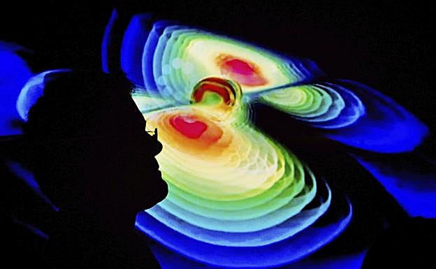 Un científico observa una representación de las ondas gravitacionales.
