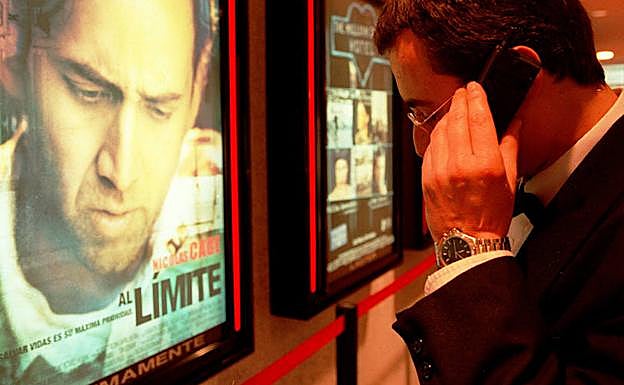 Un hombre habla por el móvil en un cine.