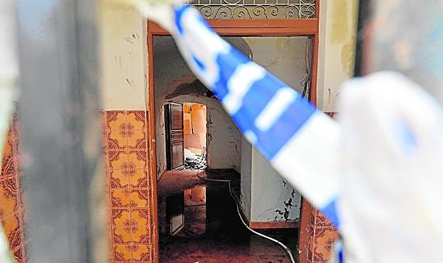 Interior de la vivienda, con charcos de agua y basura, a la que no se puede acceder por riesgo de derrumbe y que ha sido precintada. AGM