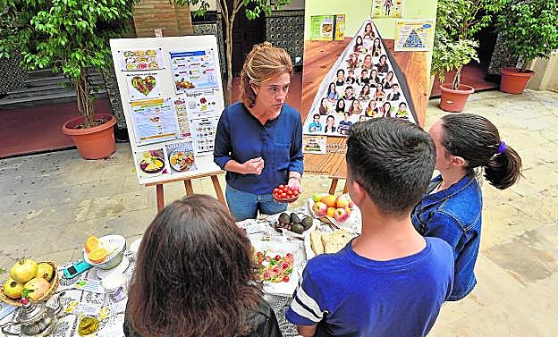 Una monitora da pautas a un grupo de alumnos sobre la dieta mediterránea. 