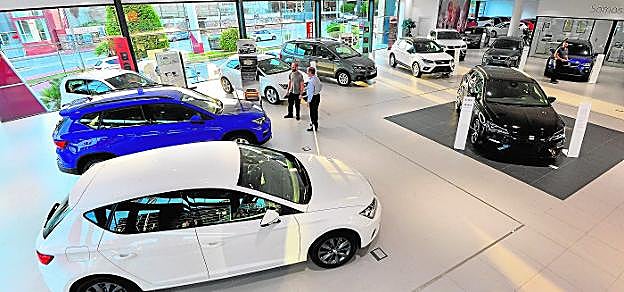 Panorámica del expositor de coches del concesionario Seat en Espinardo, ayer, con su gerente Antonio Nicolás y otro empleado de la firma. 