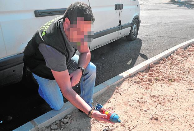 Un guardia civil muestra la granada de mortero que provocó el desalojo de la planta. 