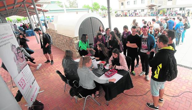 Un grupo de alumnos hace cola para recoger su carné de estudiante, en el campus de Los Dolores, ayer durante la fiesta de bienvenida universitaria. 