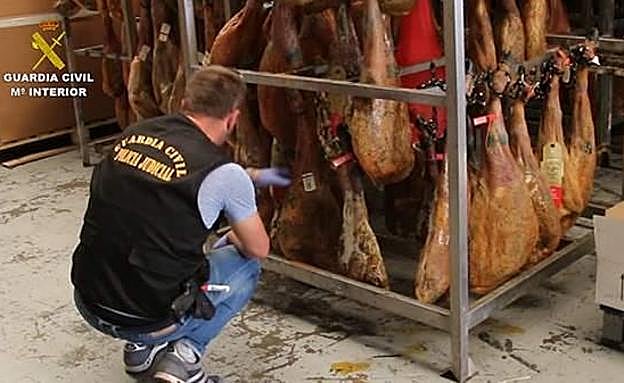 Un agente de la Guardia Civil examina los productos en mal estado.