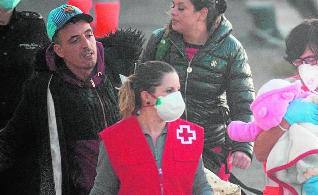Voluntarias de Cruz Roja atienden al bebé que llegó en la tarde de ayer a bordo de una de las pateras interceptadas.