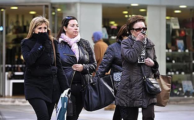 Varias personas se protegen del frío por las calles de Murcia en una imagen de archivo. 