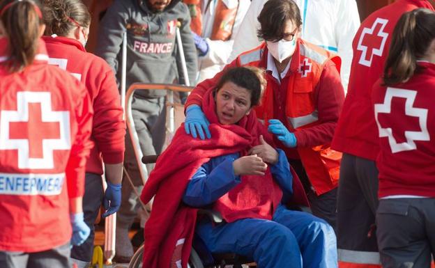 Personal de Cruz Roja atiende a una mujer, ocupante de la última patera que llegó a costas de la Región. 