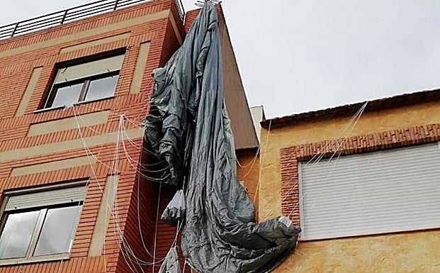 El paracaidista enganchado en la antena de una vivienda.