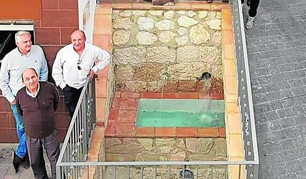 El alcalde (i), ayer, con dos vecinos junto a la pila. 