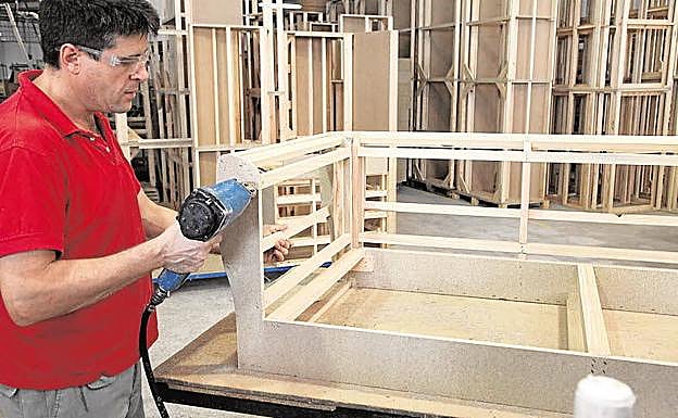 Un hombre trabajando en una fábrica de sofás de la Región.