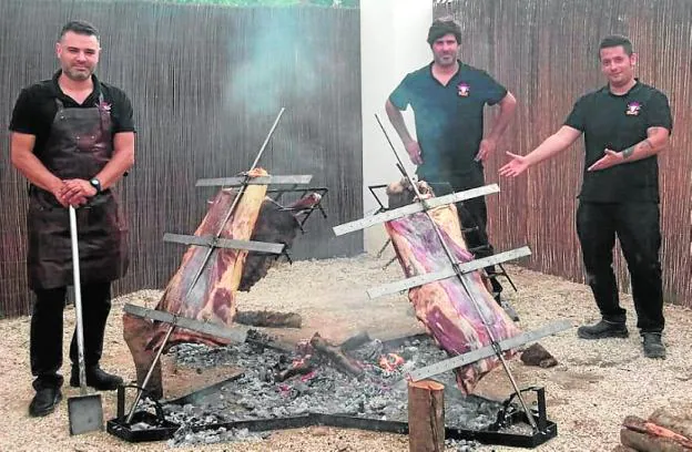 David Arijón, pala en mano, junto a Alberto Encomendero y Luis Bottini preparando la barbacoa. 