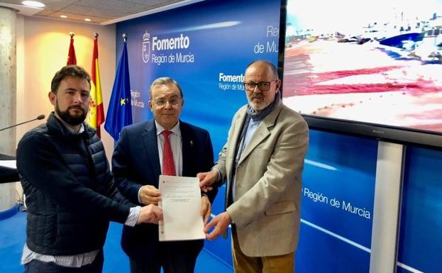 El consejero de Fomento e Infraestructuras, Patricio Valverde, junto con el presidente y secretario general de la Cofradía de Pescadores de San Pedro del Pinatar, Jesús Antonio Gómez (der.) y Francisco Rodríguez (izq.), muestran la autorización de la concesión regional de la explanada del puerto de Lo Pagán.