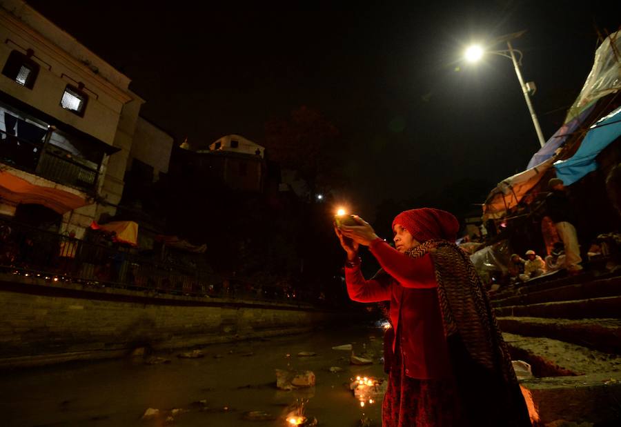 Los fieles hindúes nepalíes encienden lámparas de aceite y siembran siete tipos de semillas alrededor de las instalaciones del templo en nombre de los familiares difuntos.