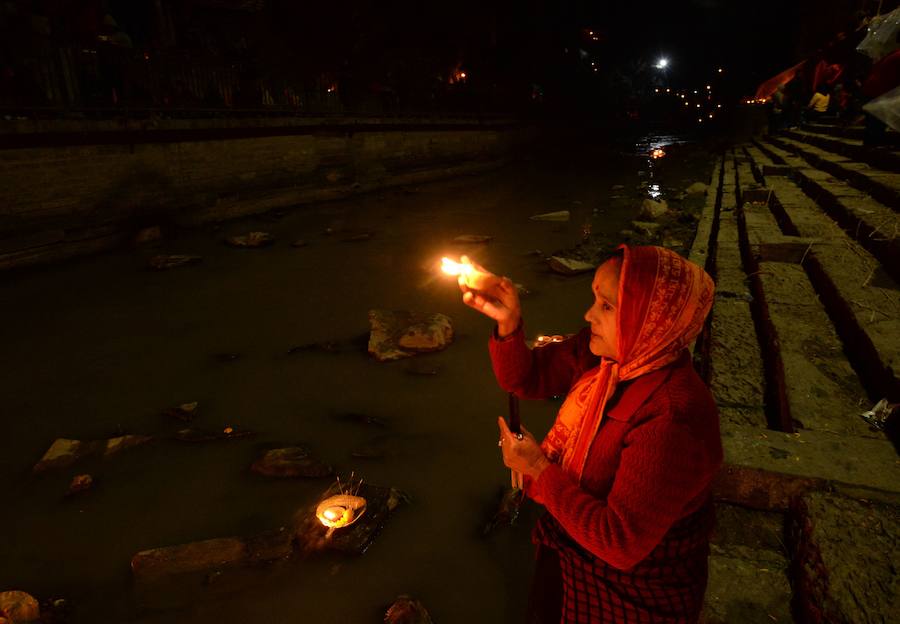 Los fieles hindúes nepalíes encienden lámparas de aceite y siembran siete tipos de semillas alrededor de las instalaciones del templo en nombre de los familiares difuntos.