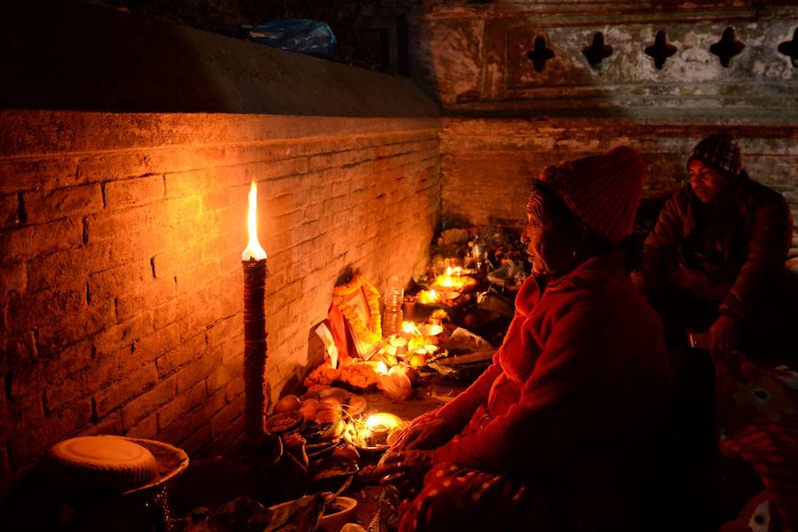 Los fieles hindúes nepalíes encienden lámparas de aceite y siembran siete tipos de semillas alrededor de las instalaciones del templo en nombre de los familiares difuntos.