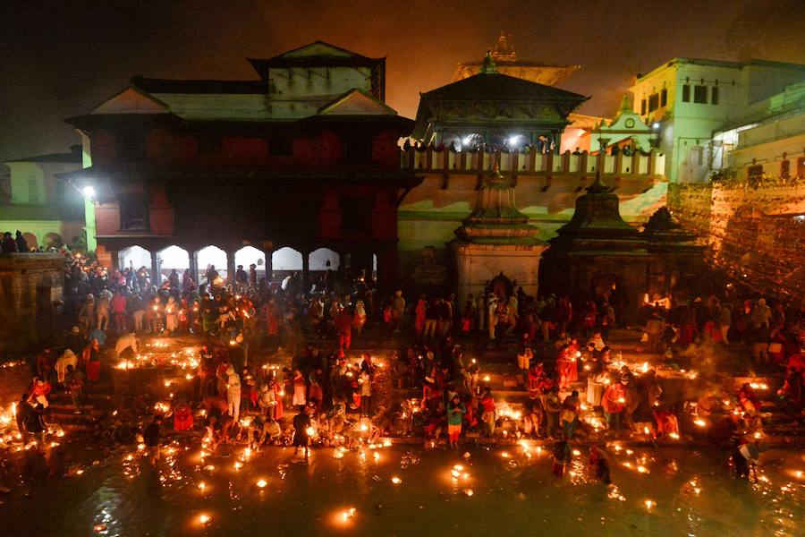 Los fieles hindúes nepalíes encienden lámparas de aceite y siembran siete tipos de semillas alrededor de las instalaciones del templo en nombre de los familiares difuntos.