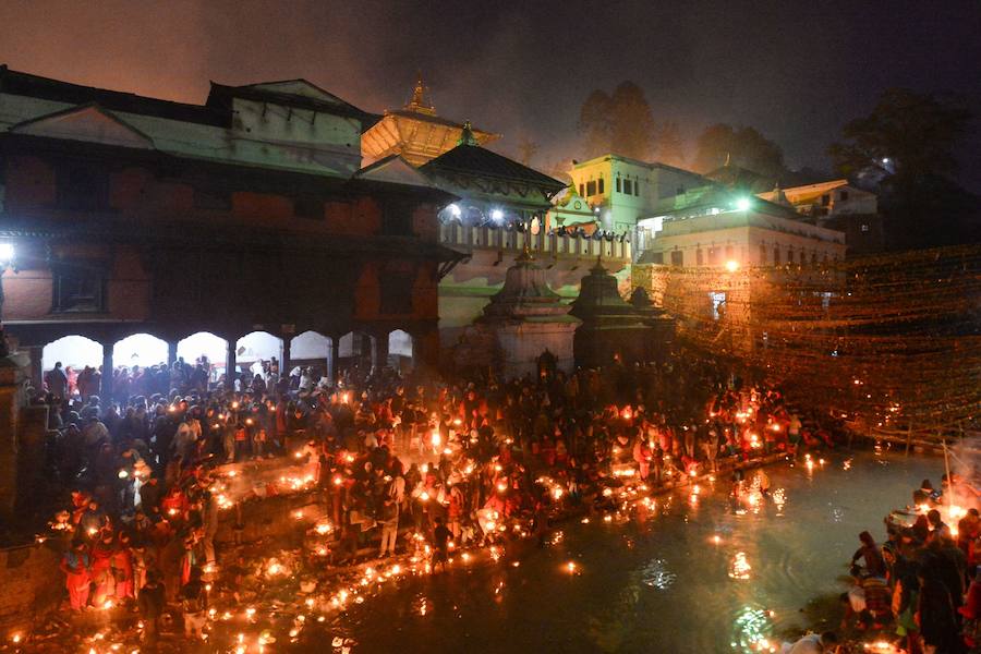 Los fieles hindúes nepalíes encienden lámparas de aceite y siembran siete tipos de semillas alrededor de las instalaciones del templo en nombre de los familiares difuntos.